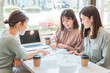 書類・資料を見ながら会議・ミーティング・打ち合わせするアジア人女性・ビジネスウーマン(営業・企画)
