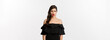 Fashion and beauty. Disappointed and upset woman in black dress staring at camera displeased, complaining with jealous look, standing over white background