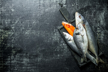 Canvas Print - Raw sea fish on wooden cutting Board.