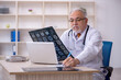 © Elnur - Old male doctor radiologist working in the clinic