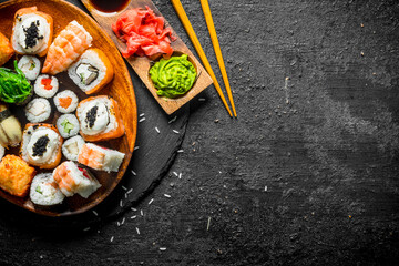 Poster - Traditional Japanese rolls and sushi in a plate on a stone Board.