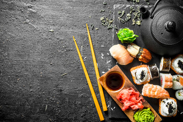 Wall Mural - Sushi rolls with shrimp and salmon on a stone Board.