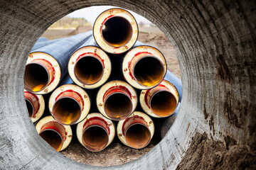 Wall Mural - Insulated pipe. Large metal pipes with a plastic sheath at a construction site. Modern pipeline for supplying hot water and heating to a residential area. Close-up.