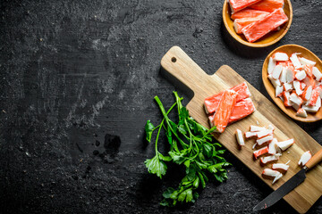 Poster - Chopped crab sticks with a knife and parsley.