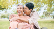 © J Maas/peopleimages.com - Couple of friends, seniors or laughing hug in nature park, grass garden or relax environment in comic, funny or silly activity. Smile, happy women or bonding retirement elderly in love trust embrace