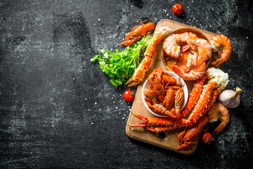 Wall Mural - Seafood. Fragrant shrimp, crayfish and crab on a wooden Board with herbs and cherry tomatoes.