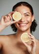 © K. A./peopleimages.com - Face, skincare and woman with lemon in studio isolated on a gray background. Fruit, organic cosmetics and happy female model holding lemons for healthy diet, vitamin c or minerals, wellness or beauty