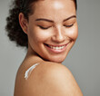 © K. A./peopleimages.com - Face, skincare and back of woman with cream in studio isolated on gray background. Cosmetics, beauty dermatology and happy female model with lotion, creme or moisturizer for healthy skin or wellness.