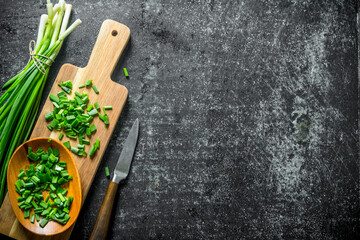 Wall Mural - Chopped green onion on a wooden cutting Board.