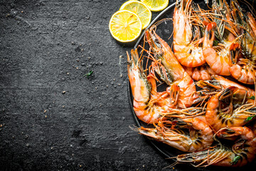 Wall Mural - Freshly cooked shrimps on a plate with slices of lemon.