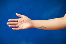 A Woman's Arm With A Lightning Bolt Tattoo.