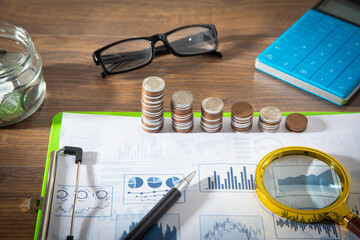 Sticker - Stack of coins on financial graphs.