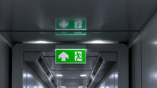 Green Emergency Exit Sign Showing The Way To Escape. Fire Exit In The Building.