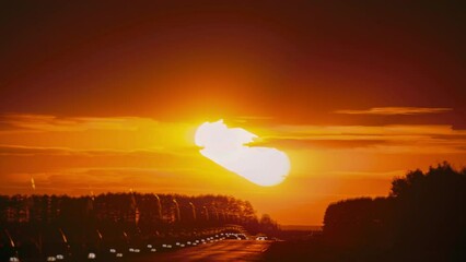 Poster - Road Trip Concept. 4k Timelapse Big Sun Sundown Above Road Landscape. Bright Dramatic Sunset Sky Natural Background. Bewitching Illusion Of Car Silhouettes. Sunset Time Lapse, Time-lapse In Yellow