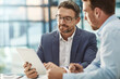 © Grady R/peopleimages.com - Tablet, meeting and teamwork of business people in office discussion. Collaboration, technology and men or employees with touchscreen planning sales, marketing or advertising strategy in company.