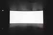 © diy13 - Cinema Theater. empty white cinema screen on a stand in the auditorium in the dark.
