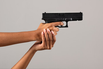 Female black hands with gun