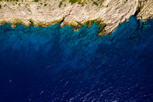 Bird's-eye View Of A White Yacht And A Yellow Lifeboat In The Azure Sea. Drone Shot Top View On The Mediterranean