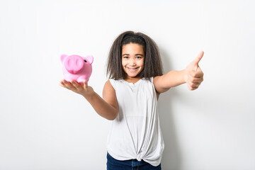 Adorable 9 years child girl on studio white background holding piggy bank