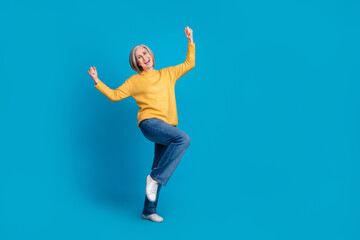 Full body portrait of cheerful overjoyed person raise fists shout yes empty space ad isolated on blue color background