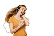 Adorable redhead young woman enjoying great sound in new headphones, sings loudly, holds cellular, smiles broadly, wears orange casual clothes, over transparent background. Sincere people emotions.