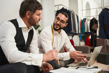 Wall Mural - Two couturiers sitting at table during conversation