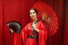 A Girl In A Red Kimono With A Red Umbrella And A Black Fan On A Red Background
