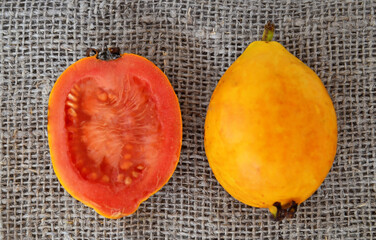 Wall Mural - Ripe guava fruit on a burlap background.Psidium guajava.Tropical fruits,healthy food or diet concept.
Selective focus.