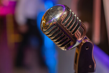 Wall Mural - Retro microphone against blur colorful light restaurant background.