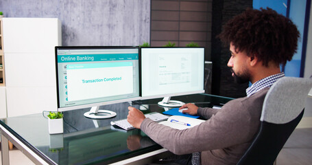 Poster - young businessman looking at invoice while doing online banking