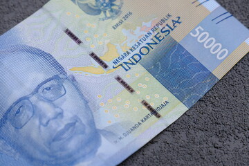 a sheet of Indonesia Rupiah 50000 on dark background, dark financial economic concept