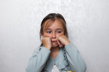 sad girl sitting on a light background.