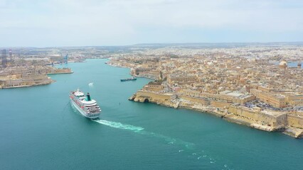 Wall Mural - Cruise liner ship in ocean floats out of the historic bay. Aerial top view