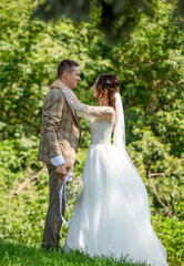 Wall Mural - The bride and groom in a wedding dress in nature.