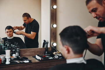 Wall Mural - Barber shaving caucasian man in barber shop