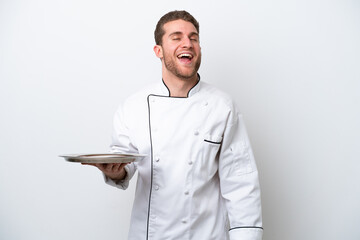 Wall Mural - Young caucasian chef with tray isolated on white background laughing