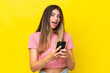 © luismolinero - Young caucasian woman isolated on yellow background surprised and sending a message