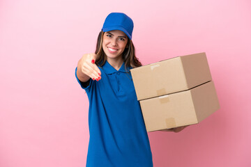 Wall Mural - Delivery Italian woman isolated on pink background shaking hands for closing a good deal