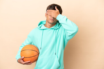 Handsome young basketball player man isolated on ocher background covering eyes by hands. Do not want to see something