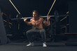 © USM Photography - Muscular man doing squats with barbell in a gym. Male bodybuilder doing workout Confident young man doing barbell workout in gym Powerful attractive man