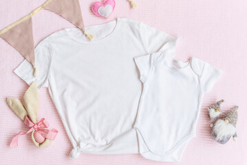 Wall Mural - Easter mom and kids mockup white t-shirt and baby bodysuit onesie with bunny and easter eggs on pink cover background. Flatlay, top view, copyspace.