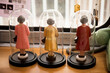 Photographie de trois statuettes sous cloches de la reine d'Angleterre, Elizabeth II, saluant de dos par la fenêtre.