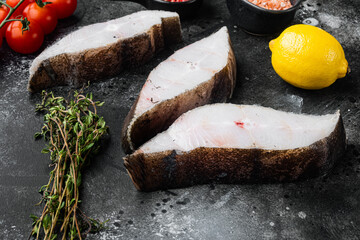 Wall Mural - Chilled halibut steaks, with ingredients and rosemary herbs, on black dark stone table background