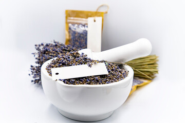 culinary lavender seeds in white bowl near dried lavender bouquet