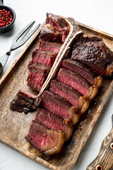 Wall Mural - T bone steak is grilled sliced on a piece. Aged Barbecue Porterhouse Steak, on white stone  background