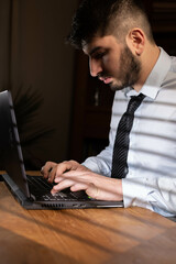 Wall Mural - jeune employé de bureau ou homme d'affaire fatigué et stressé travaille tard au bureau avec son ordinateur portable