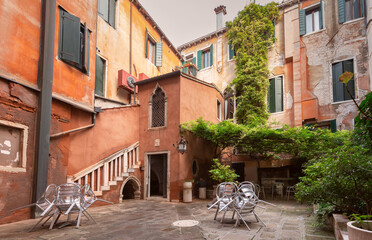 Wall Mural - Small cozy traditional patio with green bushes in Venice.