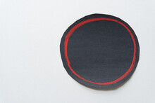 Black Paper With Red Ring Isolated On Blank Paper