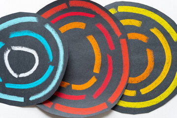 Sticker - roughly round black paper circles with segmented solid lines in primary colors