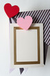 wooden heart painted pink and red with invitation card and folded scrapbook paper sheets